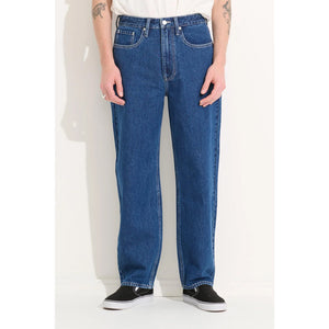 Misfit Men's Makers Relaxed Jean - Indigo. Soft rinse wash using sustainably sourced premium yarn dye denim. Relaxed fitting through the leg and with a 30 inch inseam. Features a fixed waist, functional fly & belt loops like a classic 5 pocket jean but with a signature mismatched back pocket detail.