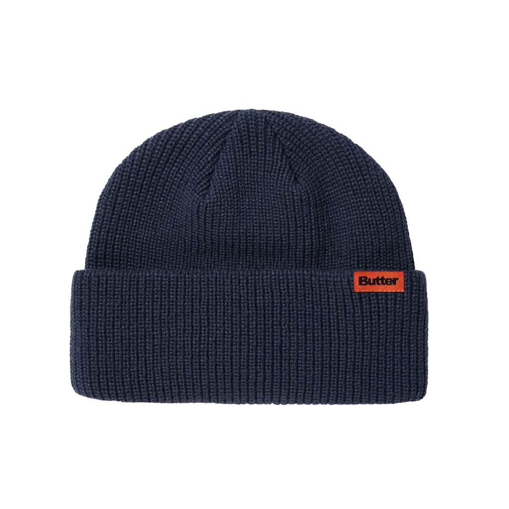 Butter Goods Tall Wharfie Beanie - Navy. Loose knit acrylic fold beanie. Tall wharfie fit. Woven label on front. Size: OSFA. Shop Butter Goods online with Pavement skate store and enjoy free Aotearoa shipping over $150, same day Ōtepoti delivery and easy returns.