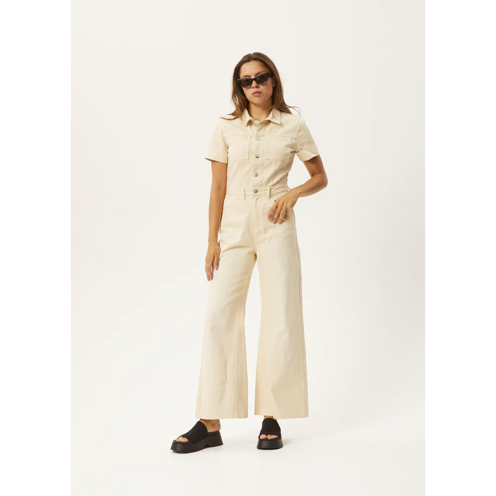 Afends Sand Miami Denim Flared Jumpsuit - Sand. Womens Denim Jumpsuit. Flared Leg. 100% Organic Cotton Denim, 12.8oz. Shop women's jumpsuits from Afends, Dickies, Carhartt WIP, Thing Thing and Misfit. Free NZ shipping over $150. 