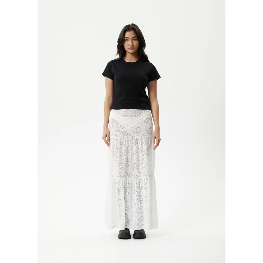 Afends Poet Lace Maxi Skirt - White. Womens Lace Tiered Maxi Skirt. Stretch Lace. Sheer. Elasticised Waist. Tight fitted. True to size. 90% Recycled Nylon, 10% Spandex Lace. Shop Afends clothing online with Pavement and enjoy free NZ shipping over $150, same day Dunedin delivery and easy returns.