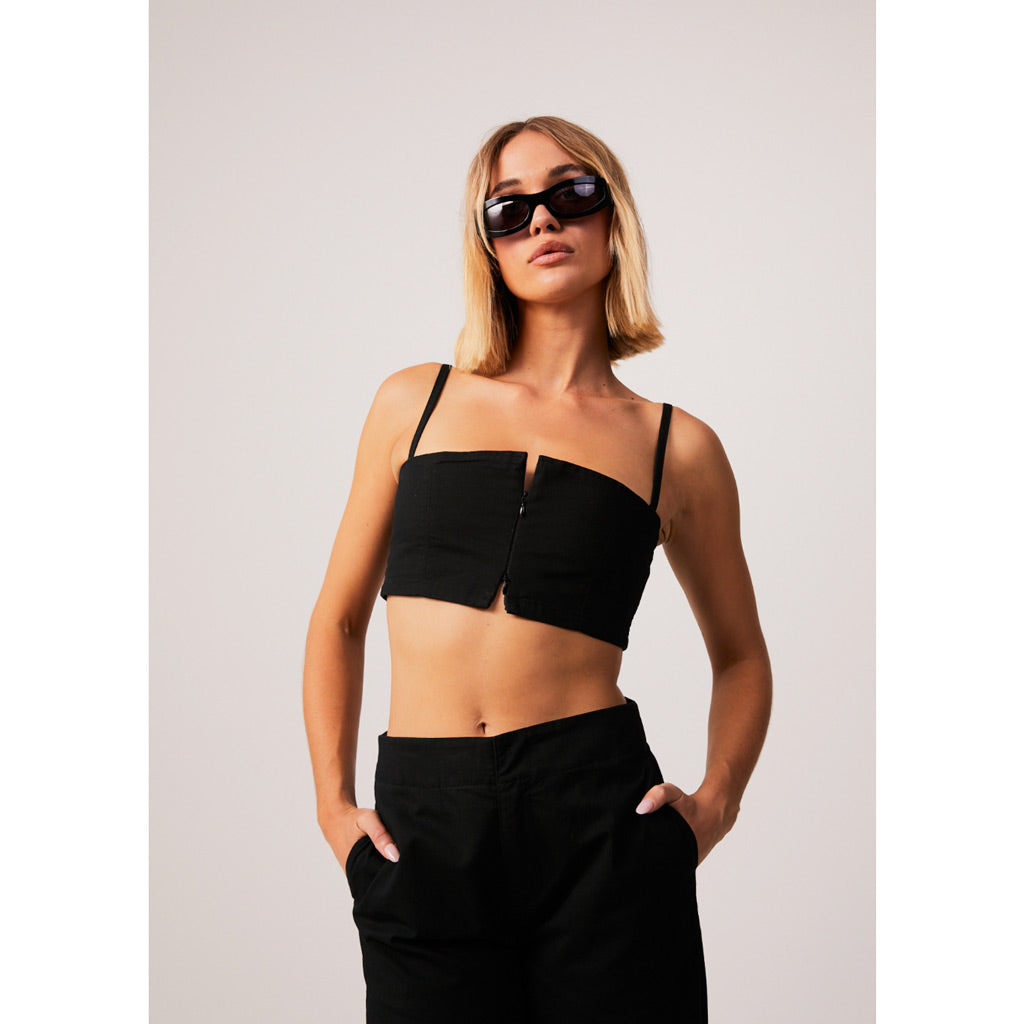Afends Cola Recycled Panelled Crop Top - Black. Spaghetti strap crop top with front zip closure.  58% Organic Cotton 40% Recycled Polyester 2% Spandex, 6.8oz. Shop women's Afends tops, dresses, pants, hemp denim and accessories. Free N.Z shipping on orders over $100. Pavement skate shop, Dunedin.