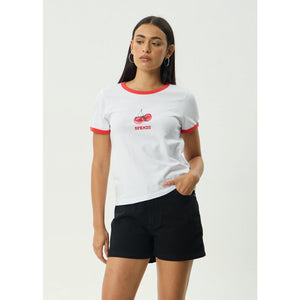 Woman wearing a white t-shirt with red accents and black shorts on a light gray background | Afends Abiza Ringer Tee - White | Free Aotearoa NZ shipping on your Afends orders over $100* when you shop with Pavement Skate Store!