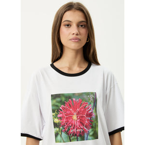 Person wearing a white t-shirt with a colorful butterfly graphic and text on a plain background