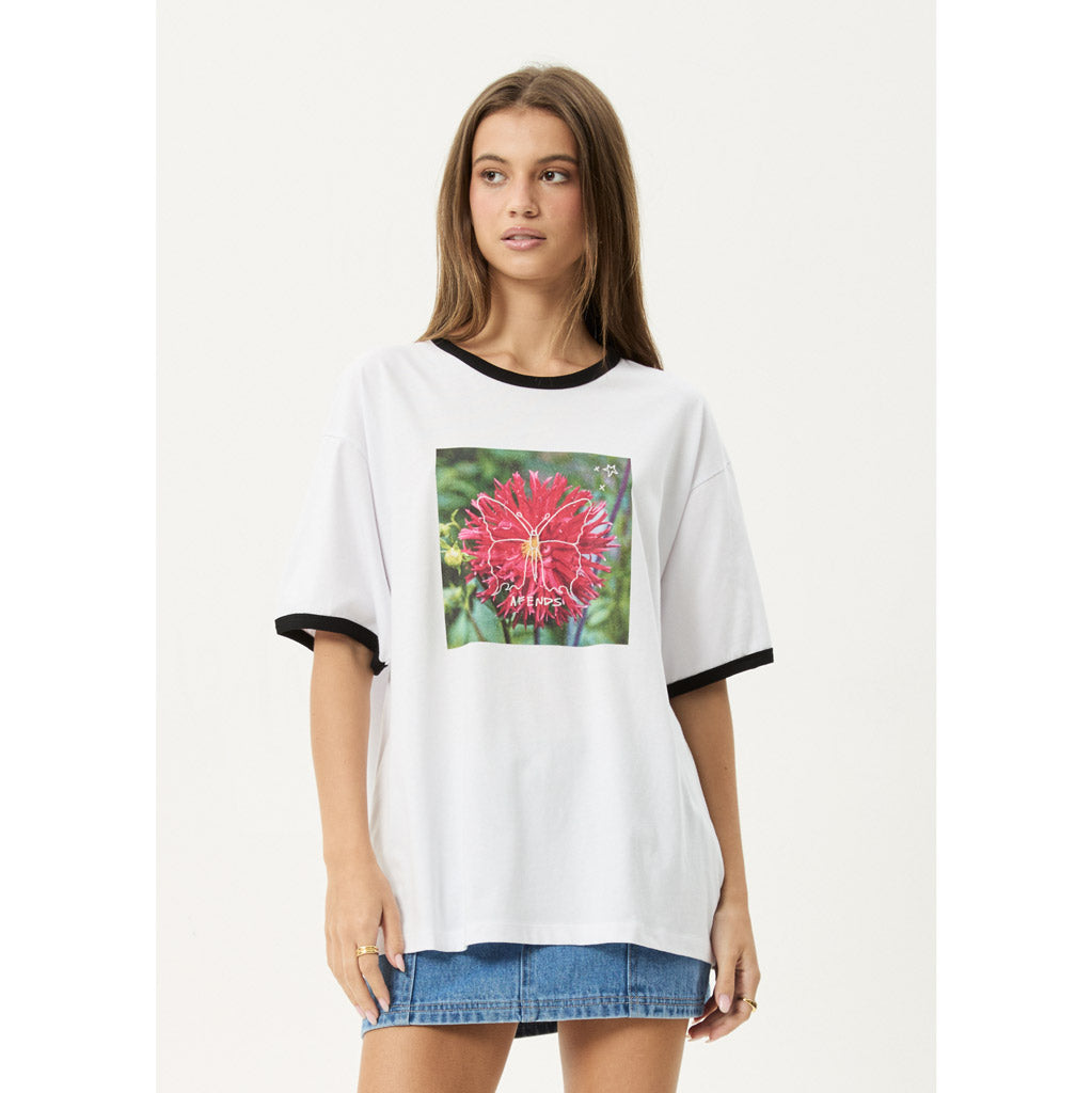 Woman wearing a white t-shirt with a colorful flower graphic on a plain background | Afends Open Up Oversized Tee - White/Black | Free Aotearoa NZ shipping on your Afends orders over $100* when you shop with Pavement Skate Store!