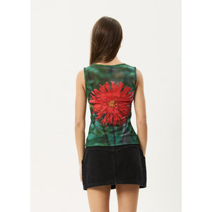 Woman wearing a sleeveless top with a red floral design on a white background