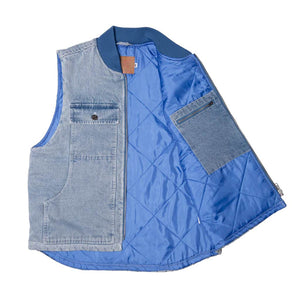 Hoddle Zip Up Carpenter Vest - Blue Denim. 16oz quilted denim vest. quilted polyester lining. Two lower-front pockets with quilt lining. Interior pocket with zipper closure. 2 top pockets. Drop tail hem. ribbed neck. Denim Appliqué back logo . Quilted brick. Quilted design inspired by Andre Piguet “Chamber” painting.