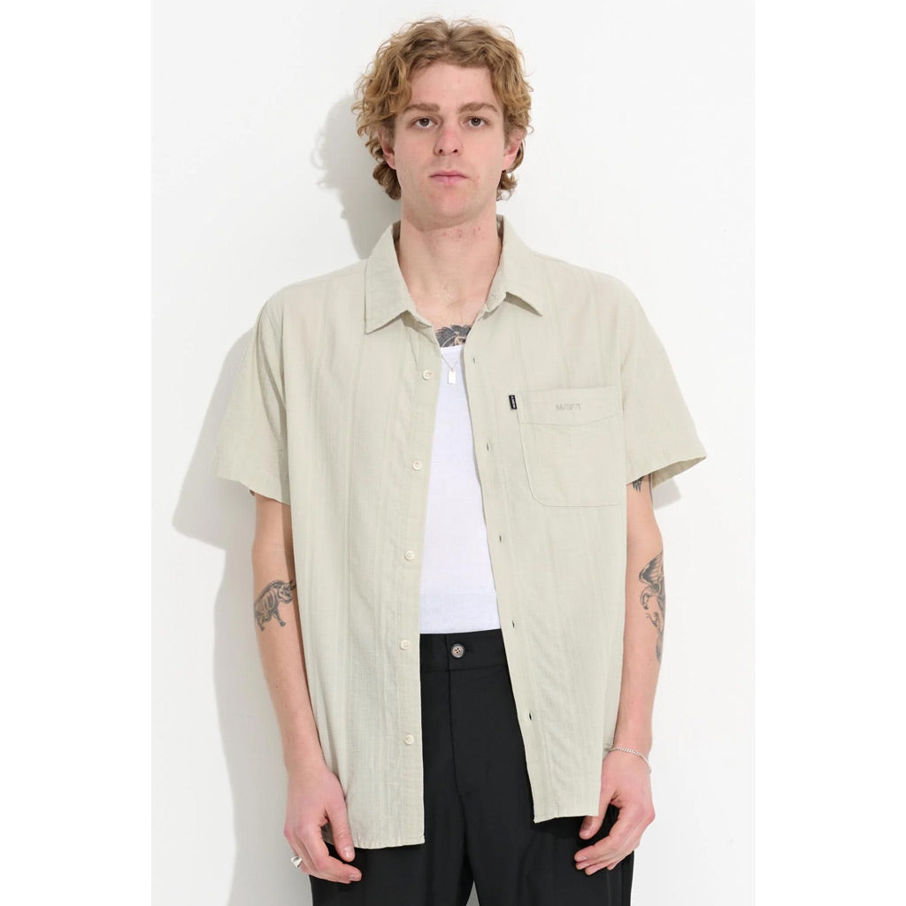 Misfit Suncut SS Shirt - Light Artichoke. The 'Suncut SS Shirt' in Light Artichoke is a short-sleeved button-up shirt with classic style collar. Left chest pocket with embroidered graphic. Flag label on pocket. 100% Textured Cotton. Finished with softening garment wash & premium trims.