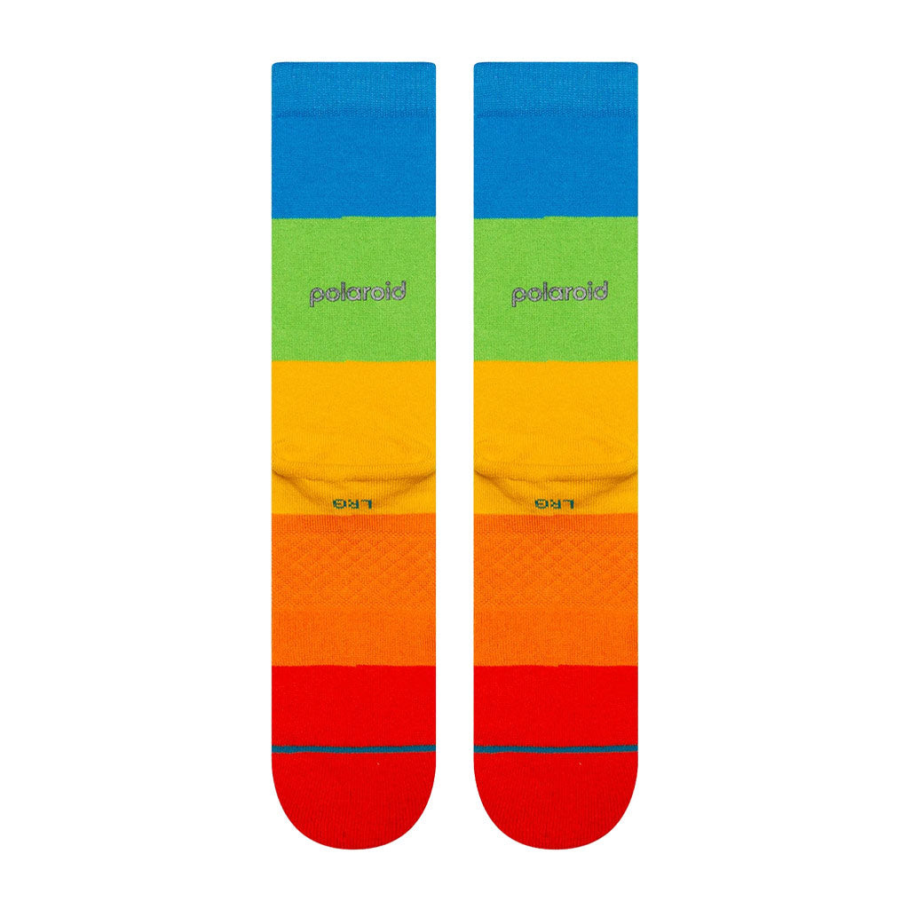 Colorful socks with a blue, green, yellow, and red pattern on a white background