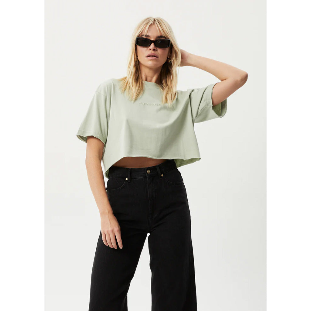 Afends Restless Slay Cropped Recycled Tee - Eucalyptus Womens Basic Cropped T-ShirtBaggy Relaxed FitWide Ribbed NecklineCropped Design Model wears a size S / AU 8 / US 4 and is 178cm tall. 50% Recycled Cotton 50% Organic Cotton JerseyMidweight, 200gsm