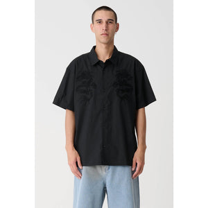 XLarge Dragon SS Shirt - Black. Oversized box-fit traditional short sleeve shirt. Chainstitch design on chest panels. Button up front. Soft washed finish. Branded buttons. Straight hem. 100% Cotton Poplin. Shop XLarge brand clothing online with Pavement and enjoy free shipping on your XLarge order over $150.